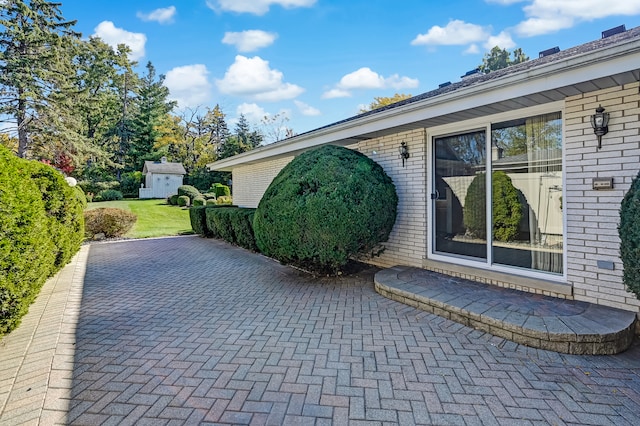 view of home's exterior featuring a patio and a storage unit