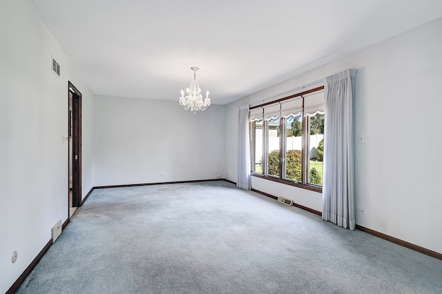 carpeted empty room with a chandelier