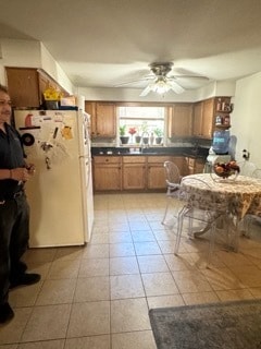 kitchen with light tile patterned flooring, ceiling fan, and white fridge