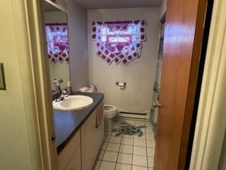 bathroom featuring a baseboard heating unit, tile patterned flooring, vanity, and toilet