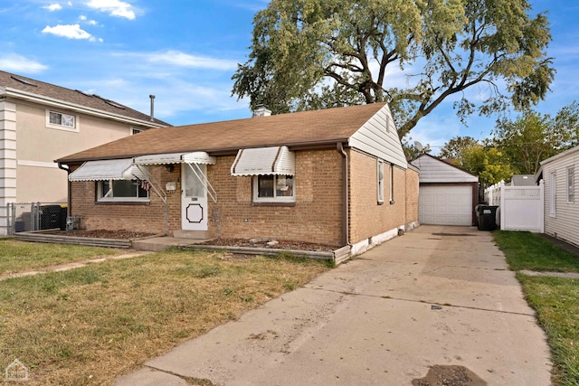 bungalow featuring a front lawn, an outbuilding, and a garage