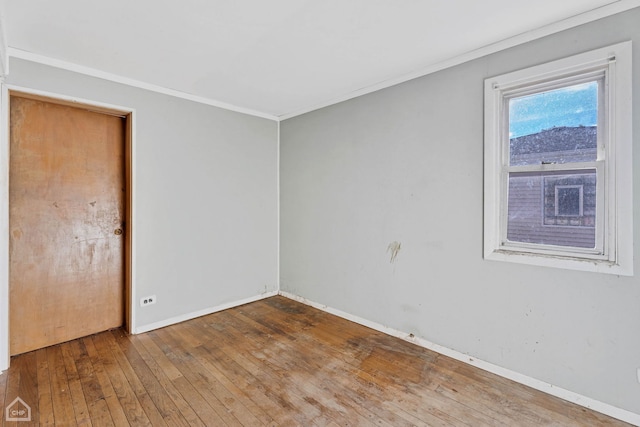 empty room featuring ornamental molding and hardwood / wood-style flooring