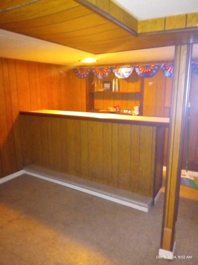 bar with dark colored carpet and wooden walls