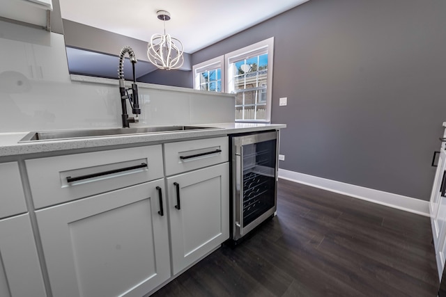 kitchen with white cabinetry, hanging light fixtures, dark hardwood / wood-style floors, and beverage cooler