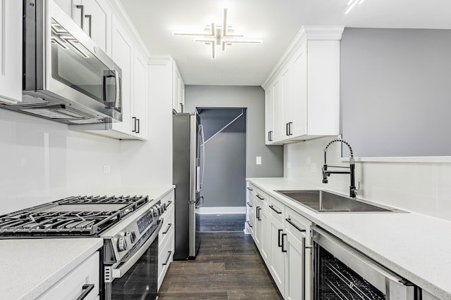 kitchen featuring beverage cooler, appliances with stainless steel finishes, white cabinetry, dark wood-type flooring, and sink