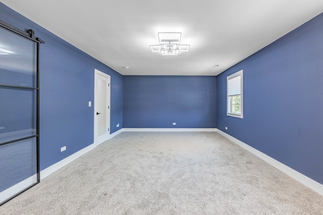 empty room with carpet floors and a barn door