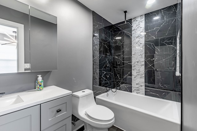 full bathroom featuring tiled shower / bath, vanity, and toilet