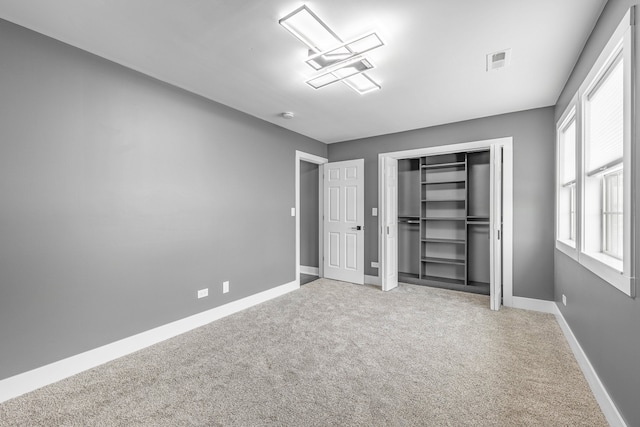 unfurnished bedroom featuring carpet flooring and a closet