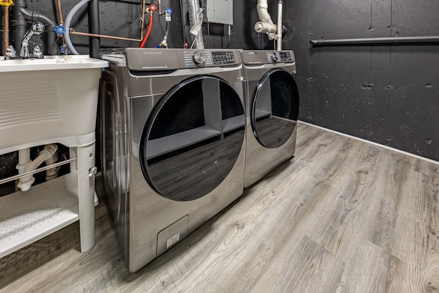 clothes washing area featuring hardwood / wood-style floors and washing machine and dryer