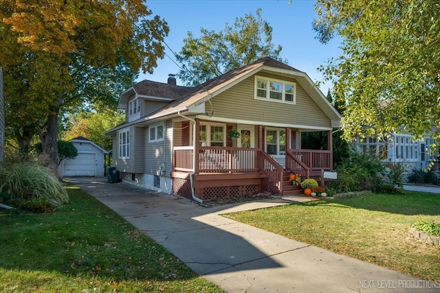 bungalow-style house with an outbuilding, covered porch, a front lawn, and a garage