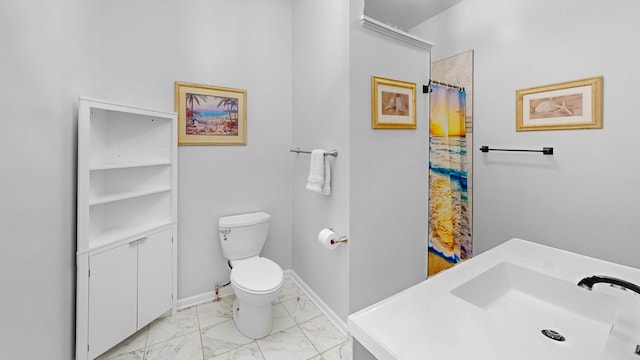 bathroom with curtained shower, baseboards, toilet, marble finish floor, and a sink