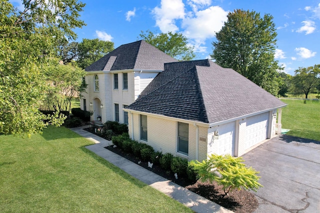 view of property exterior featuring driveway, roof with shingles, a garage, a lawn, and brick siding