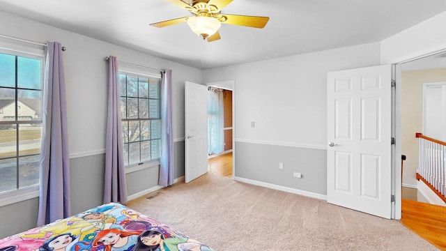 carpeted bedroom with visible vents, ceiling fan, and baseboards