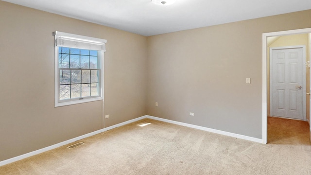 spare room featuring visible vents, baseboards, and light colored carpet