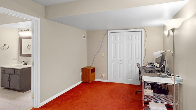 home office featuring a sink, baseboards, light carpet, and visible vents