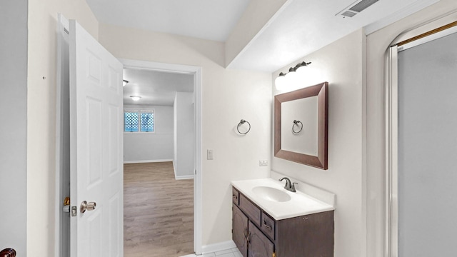 bathroom featuring visible vents, baseboards, wood finished floors, and vanity