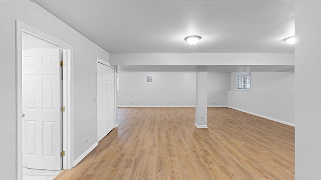 below grade area with baseboards and light wood-type flooring