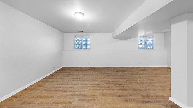 basement with baseboards and wood finished floors