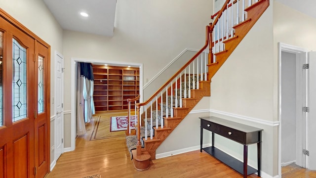 foyer entrance with stairway, recessed lighting, baseboards, and wood finished floors