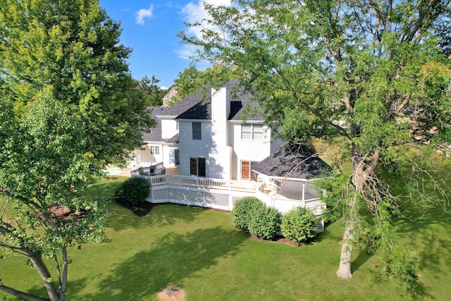 back of house featuring a lawn and a deck