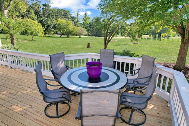 wooden terrace with a lawn and outdoor dining area