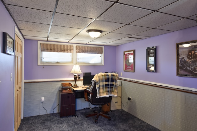 carpeted home office with a drop ceiling