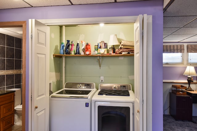 laundry room with washer and dryer and tile walls