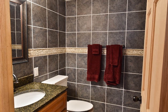 bathroom featuring tile walls, vanity, and toilet