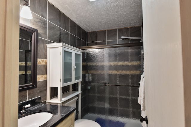 bathroom with toilet, an enclosed shower, a textured ceiling, and vanity