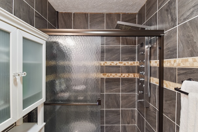 bathroom featuring a shower with door and a textured ceiling