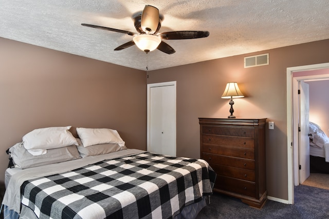 carpeted bedroom with a closet, a textured ceiling, and ceiling fan