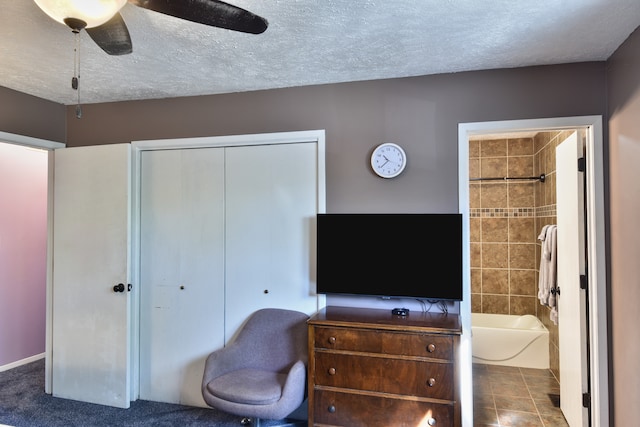 bedroom featuring a closet, tile patterned flooring, ensuite bath, a textured ceiling, and ceiling fan