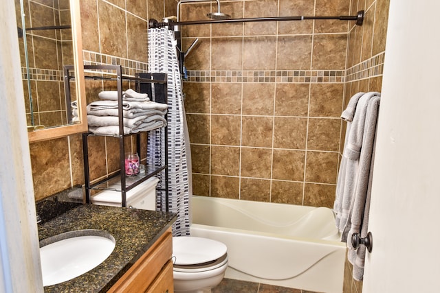 full bathroom featuring toilet, tile patterned floors, tile walls, vanity, and shower / bathtub combination with curtain