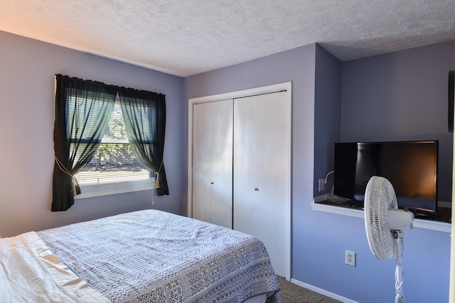 carpeted bedroom featuring a textured ceiling and a closet