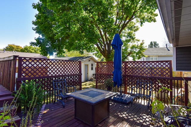 deck with a storage unit and a fire pit