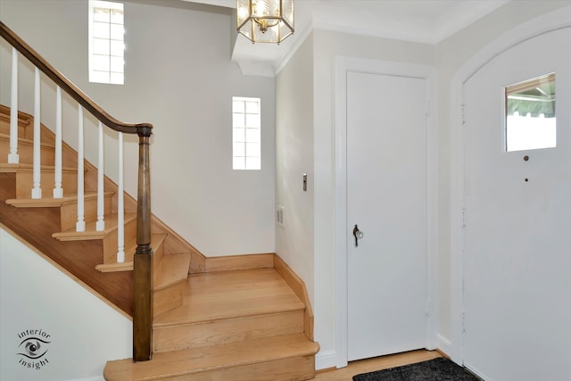 entrance foyer featuring wood-type flooring, an inviting chandelier, and plenty of natural light