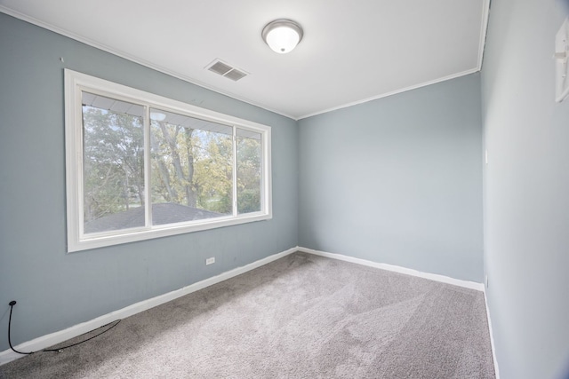carpeted spare room with visible vents, baseboards, and ornamental molding
