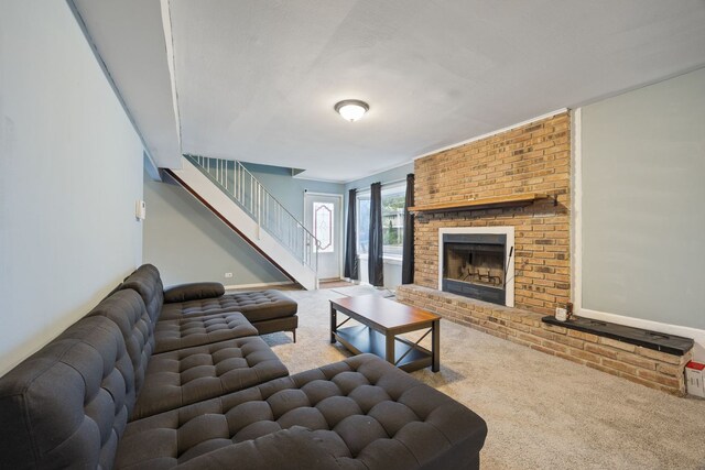 carpeted living room with a brick fireplace and stairs