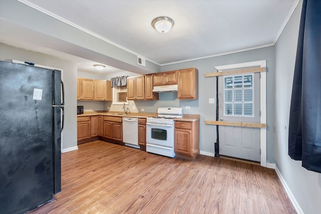 kitchen with white appliances, under cabinet range hood, light wood-style floors, visible vents, and a sink