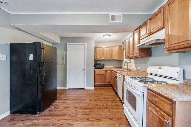 kitchen with light wood-style flooring, black appliances, under cabinet range hood, a sink, and light countertops