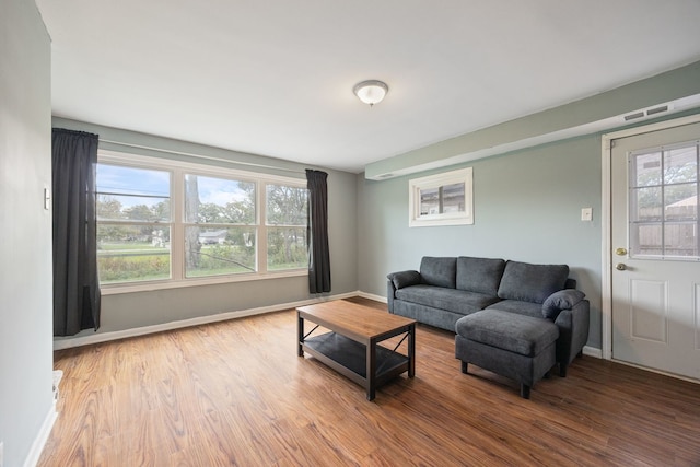living room with visible vents, baseboards, and wood finished floors