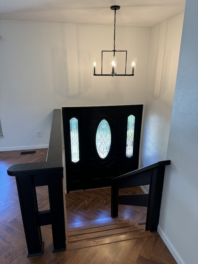 entrance foyer featuring parquet flooring and an inviting chandelier