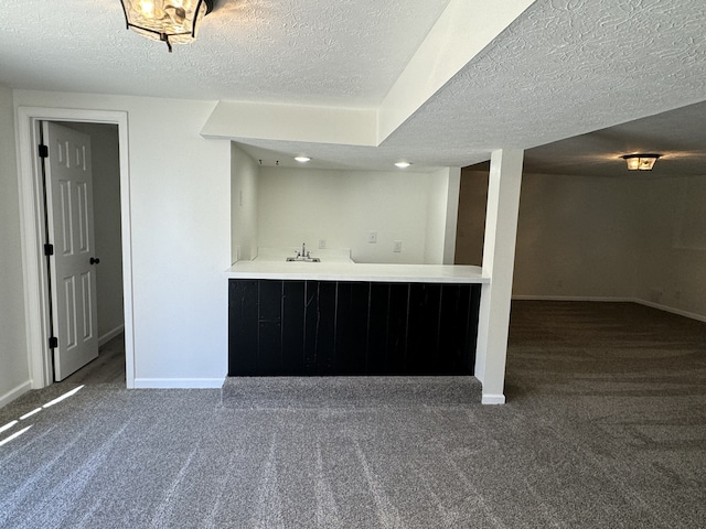 bar featuring a textured ceiling and dark colored carpet