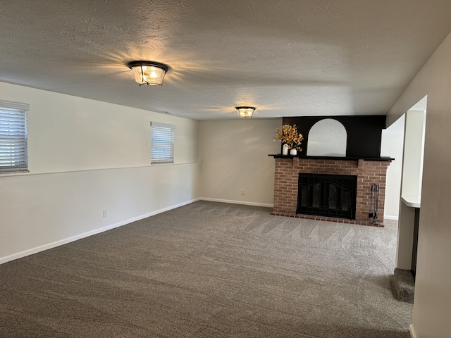 unfurnished living room featuring carpet, a brick fireplace, and a textured ceiling