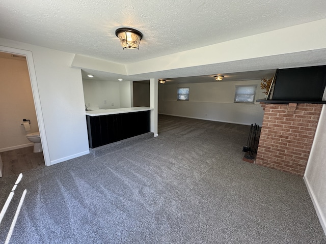 unfurnished living room featuring a textured ceiling and carpet flooring