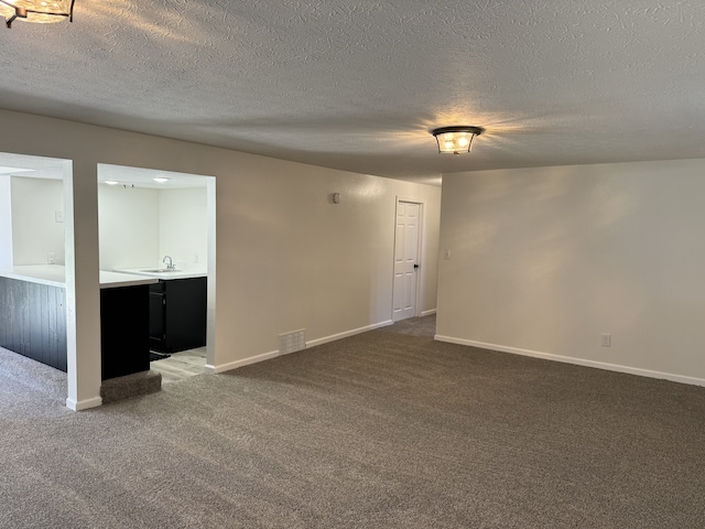 unfurnished room with carpet flooring and a textured ceiling