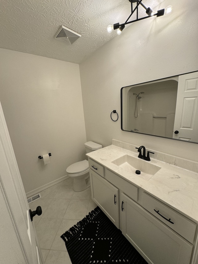 bathroom with vanity, a textured ceiling, toilet, and tile patterned floors