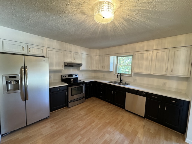 kitchen featuring light hardwood / wood-style flooring, stainless steel appliances, sink, white cabinetry, and a textured ceiling