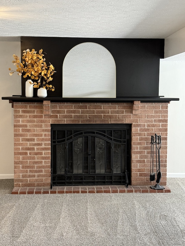 details featuring carpet flooring, a textured ceiling, and a brick fireplace