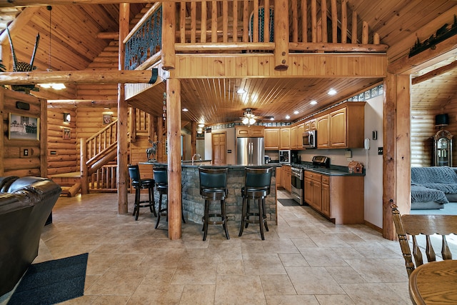 kitchen with a kitchen island, a kitchen breakfast bar, stainless steel appliances, wooden ceiling, and high vaulted ceiling